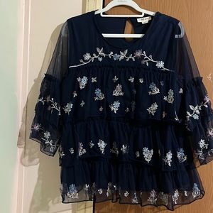 This is a floral navy blue shirt with ruffles